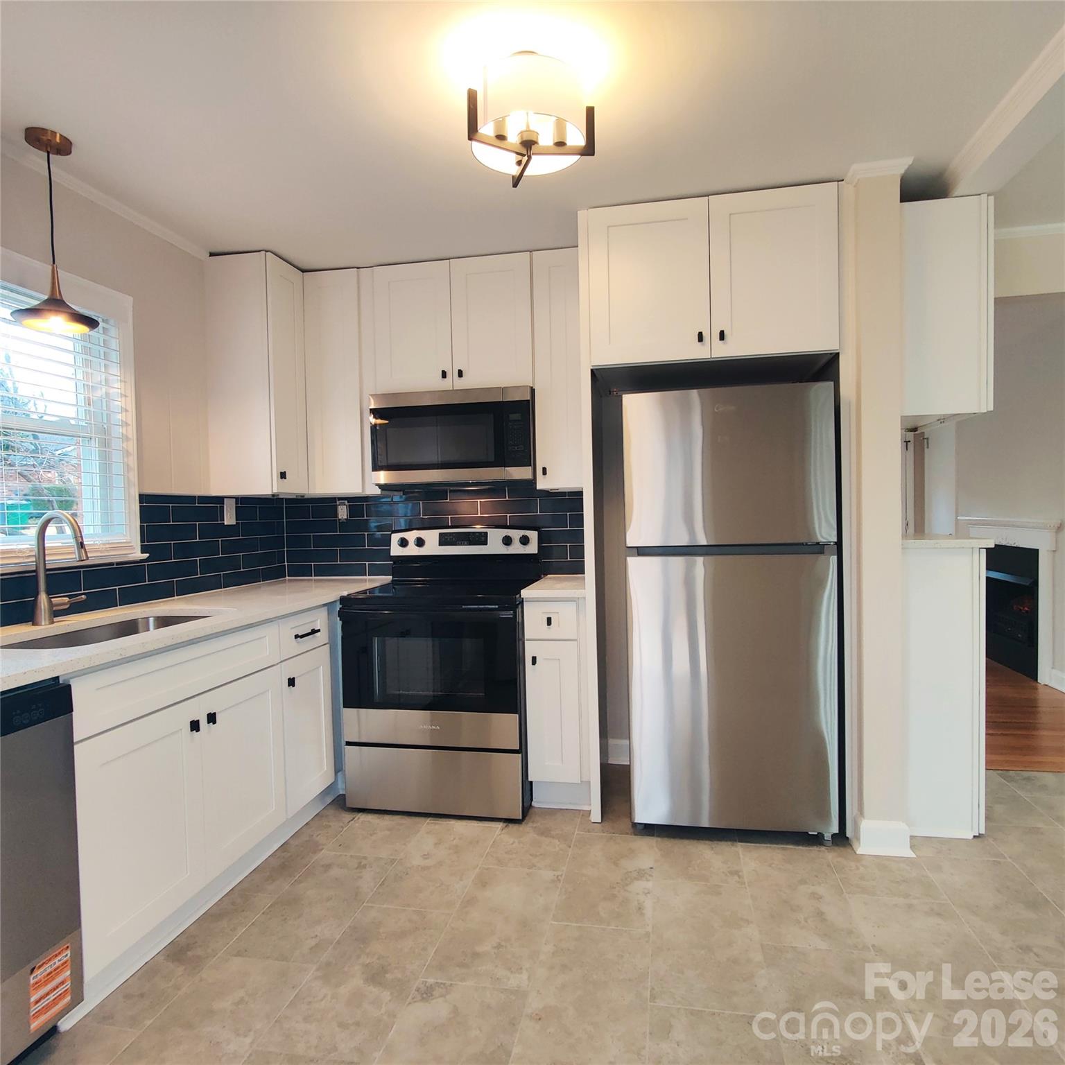 4100 Broadview Drive Charlotte, NC 28217 - Photo 3 of 24 a kitchen with granite countertop a refrigerator a stove a microwave and cabinets