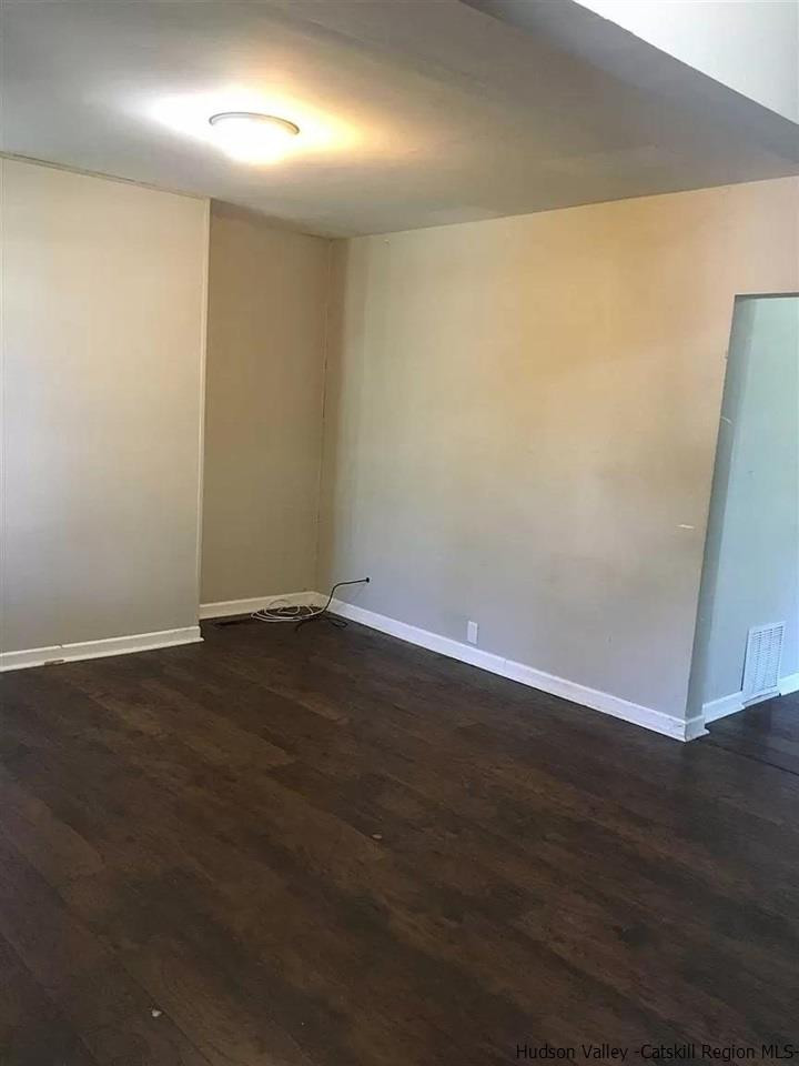 39 Spruce Street Poughkeepsie, NY 12601 - Photo 5 of 20 an empty room with wooden floor and door
