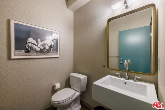 a bathroom with a toilet a sink and mirror