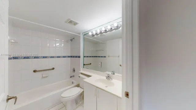 a bathroom with a toilet a sink a mirror a shower and vanity