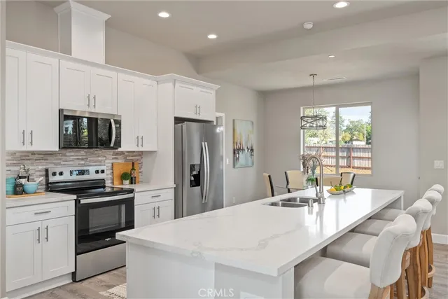 a kitchen with stainless steel appliances a stove refrigerator sink and microwave