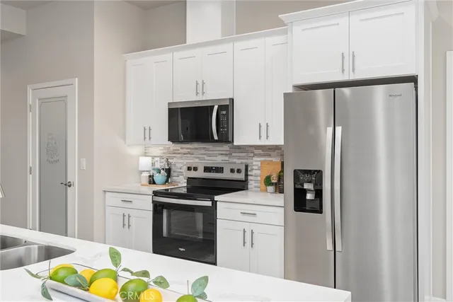 a kitchen with stainless steel appliances a stove microwave and refrigerator