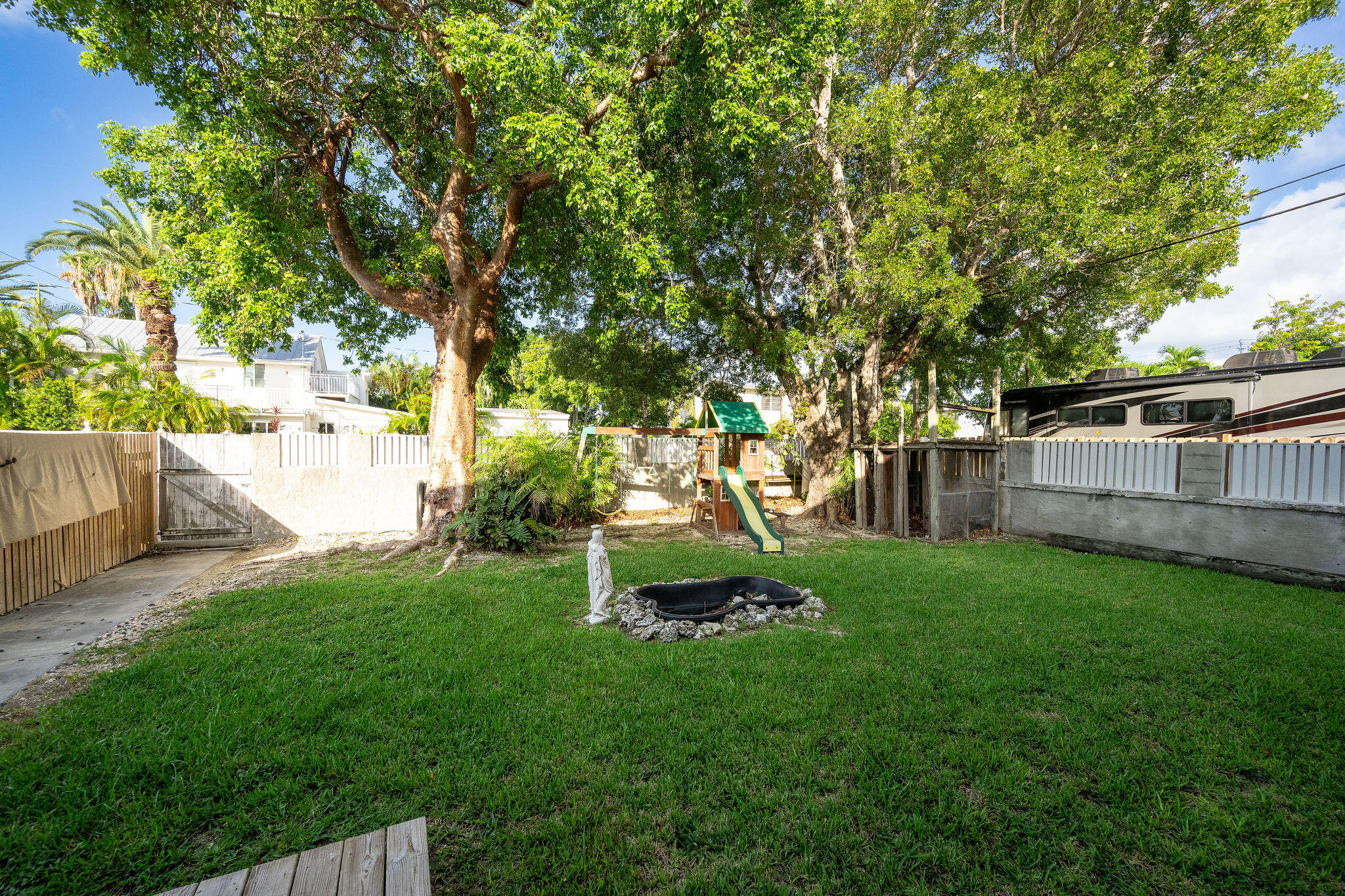 1229 5th Street Key West, FL 33040 - Photo 23 of 40 a view of backyard with table and chairs and wooden fence