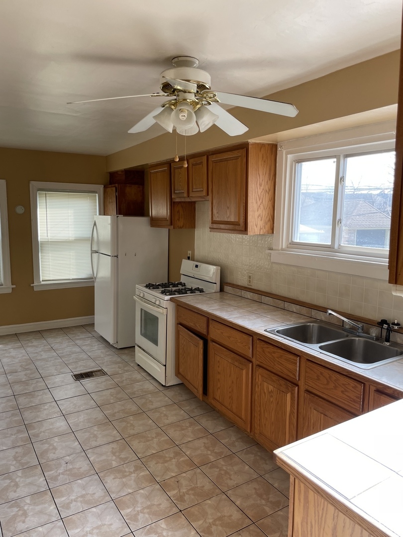 9309 South Ada Street Chicago, IL 60620 - Photo 11 of 39 a kitchen with stainless steel appliances granite countertop a sink cabinets and window