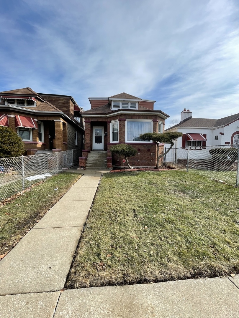 9309 South Ada Street Chicago, IL 60620 - Photo 2 of 39 a front view of a house with a yard