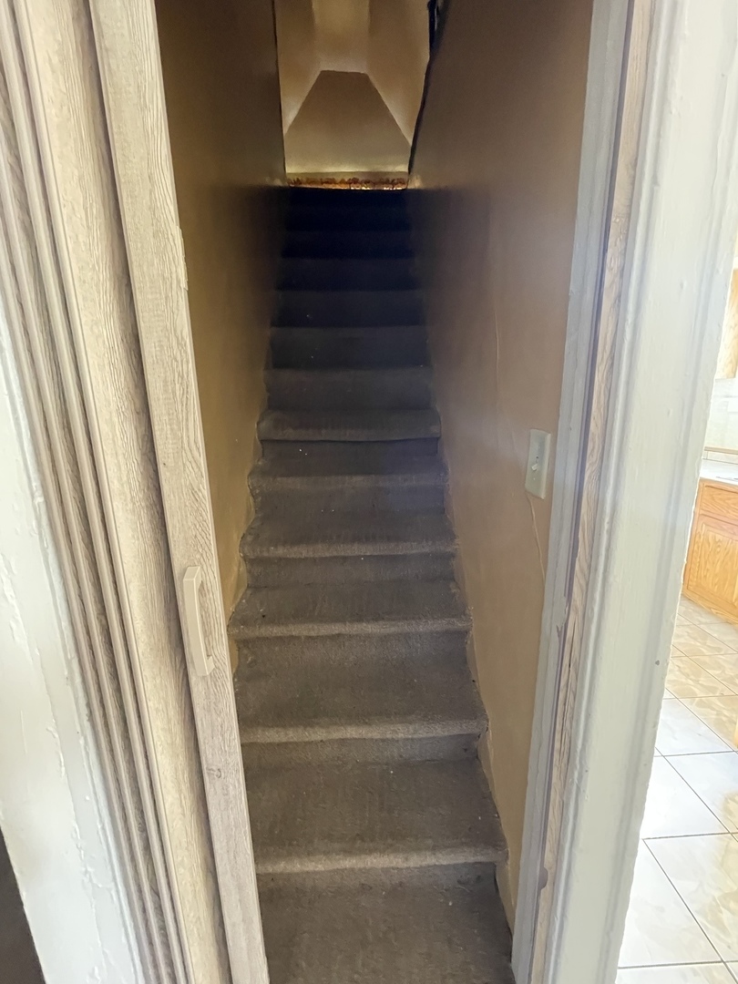 9309 South Ada Street Chicago, IL 60620 - Photo 30 of 39 a view of staircase with white walls and door