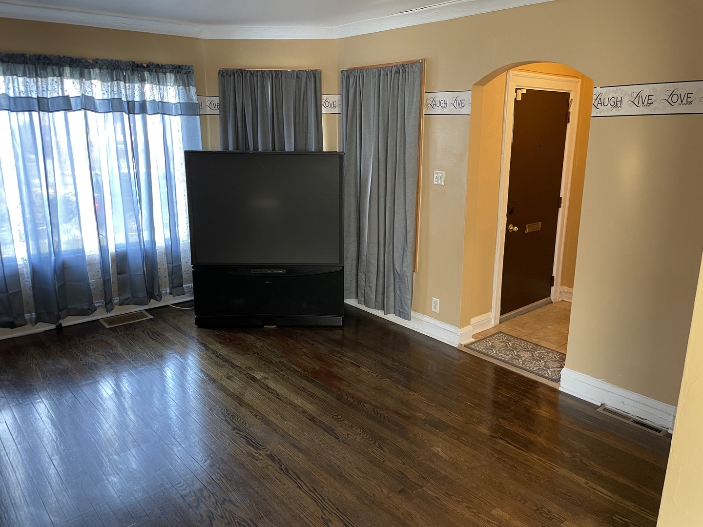 9309 South Ada Street Chicago, IL 60620 - Photo 5 of 39 an empty room with wooden floor and windows