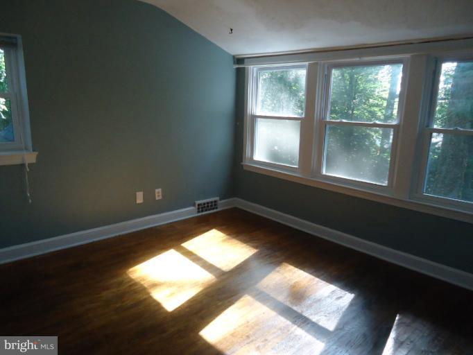 10407 Rodney Road Silver Spring, MD 20903 - Photo 7 of 9 a view of an empty room with wooden floor and a window