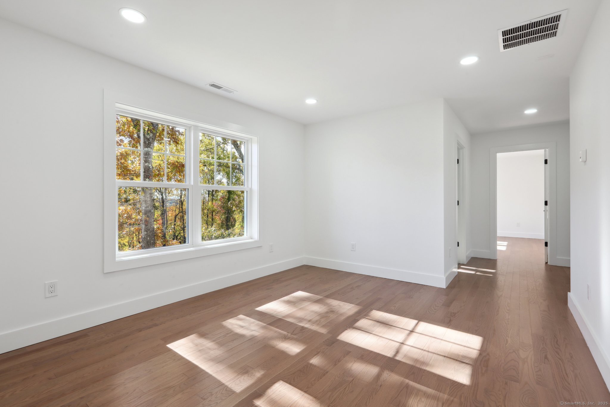 19 A Apache Drive Brookfield, CT 06804 - Photo 17 of 28 a view of an empty room with wooden floor and a window