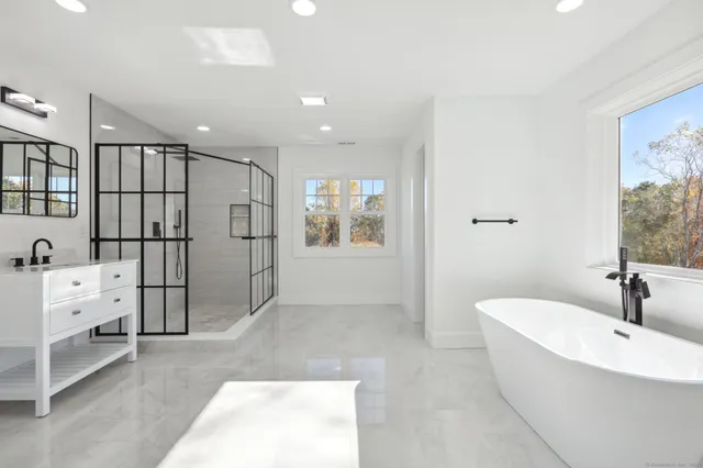 a bathroom with a tub a sink and mirrors