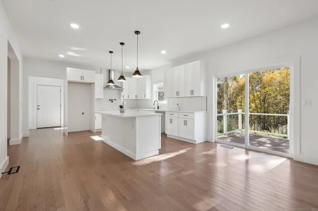 a large white kitchen with a large window appliances and cabinets