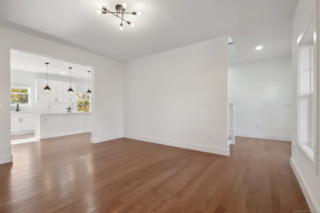 an empty room with wooden floor and cabinet