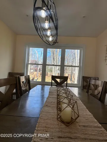 a kitchen with stainless steel appliances granite countertop a refrigerator a stove a sink and a dining table with wooden floor