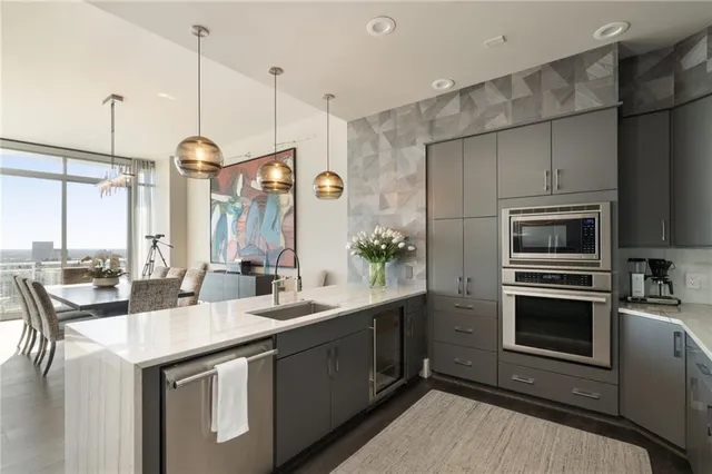 a kitchen with stainless steel appliances granite countertop a sink a stove and a refrigerator