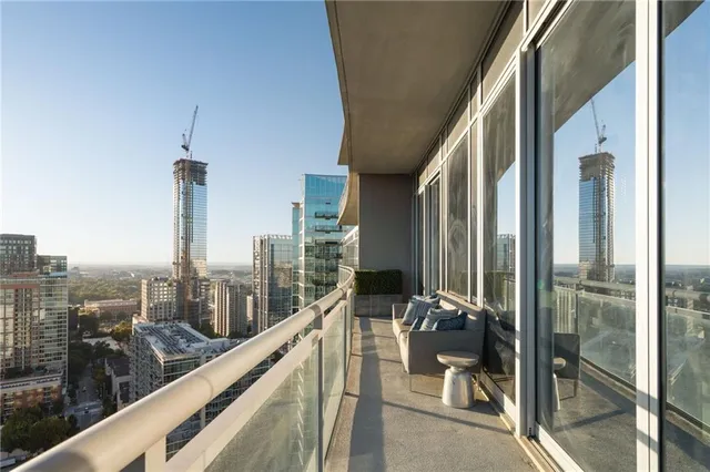 a living room with furniture a flat screen tv and a floor to ceiling window