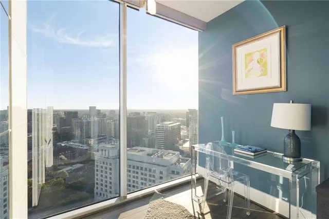 a kitchen with stainless steel appliances kitchen island granite countertop a stove a refrigerator a sink a dining table and chairs with wooden floor