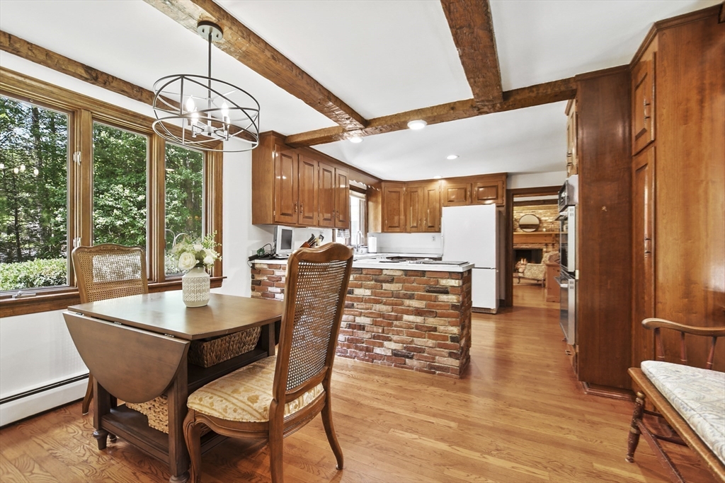 40 Herrick Road Boxford, MA 01921 - Photo 16 of 40 a dining room with wooden floor a chandelier a glass table and chairs