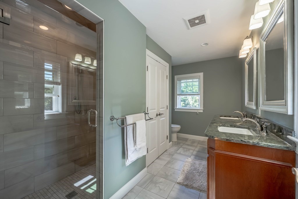 20 County Road Andover, MA 01810 - Photo 29 of 42 a bathroom with a granite countertop sink a mirror and a shower