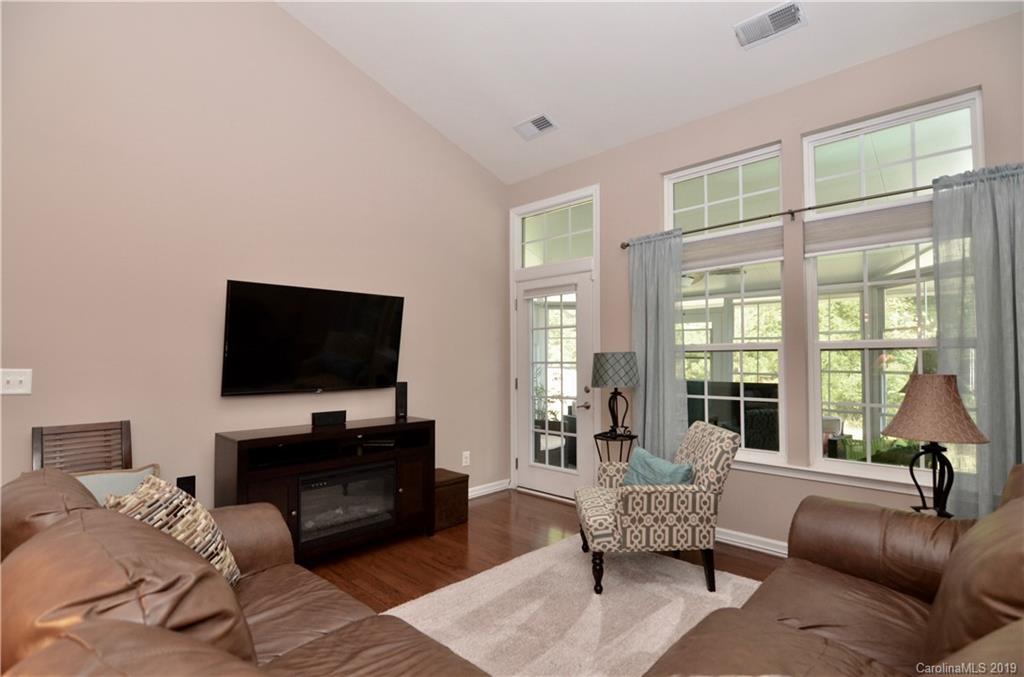 113 Inlet Point Drive Tega Cay, SC 29708 - Photo 15 of 42 a living room with furniture a flat screen tv and a large window