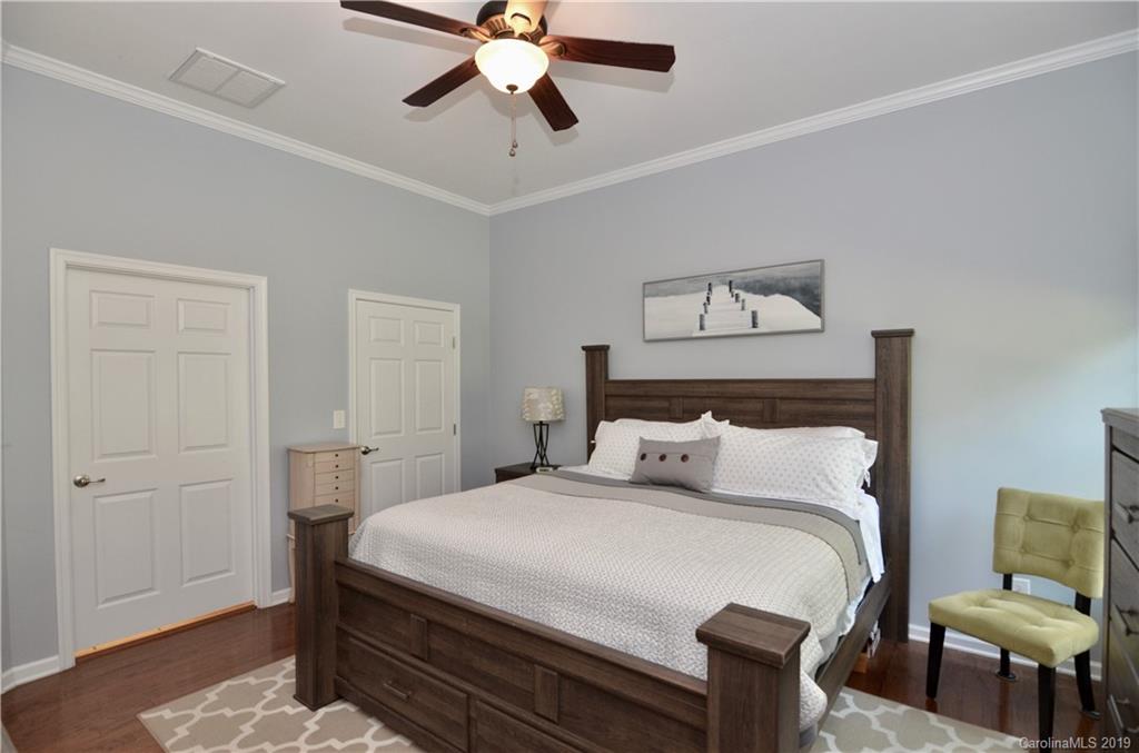 113 Inlet Point Drive Tega Cay, SC 29708 - Photo 19 of 42 a bedroom with a bed and wooden floor