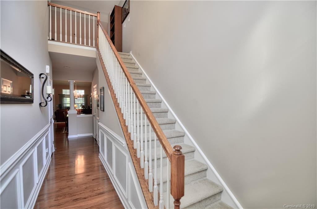 113 Inlet Point Drive Tega Cay, SC 29708 - Photo 4 of 42 a view of staircase with lots of frames on wall and wooden floor