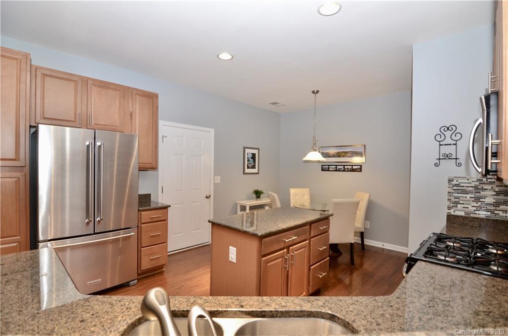 113 Inlet Point Drive Tega Cay, SC 29708 - Photo 6 of 42 a kitchen with stainless steel appliances granite countertop a refrigerator a stove a sink and a refrigerator with wooden floor