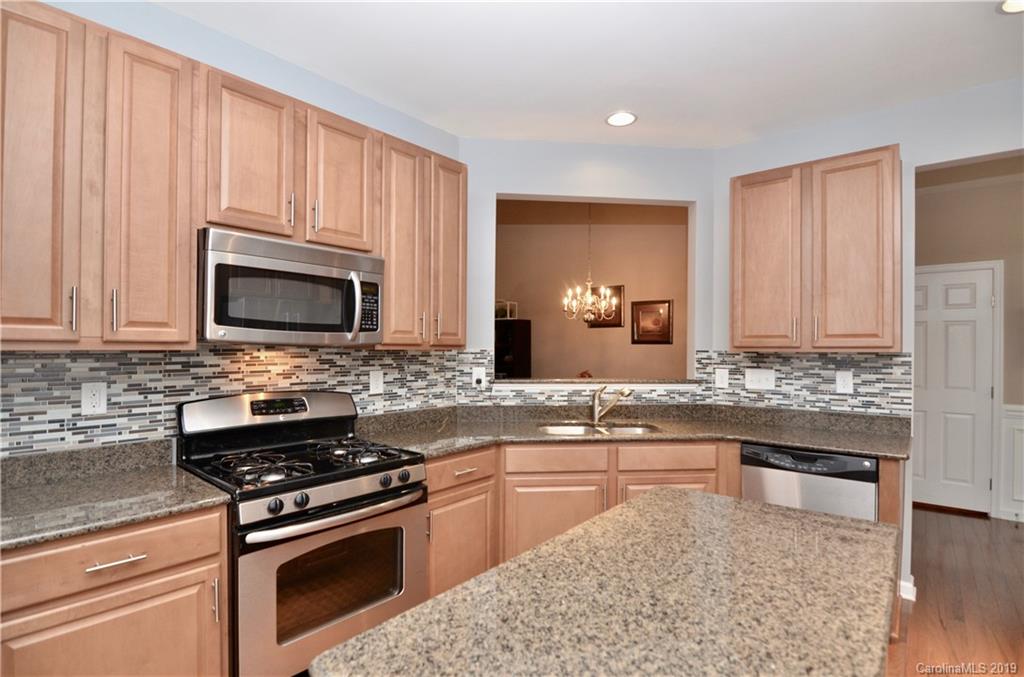 113 Inlet Point Drive Tega Cay, SC 29708 - Photo 8 of 42 a kitchen with stainless steel appliances granite countertop a stove top oven microwave and cabinets