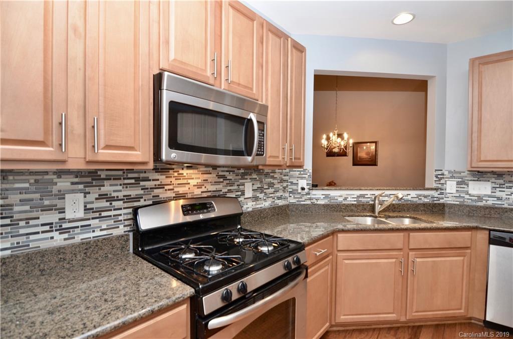 113 Inlet Point Drive Tega Cay, SC 29708 - Photo 9 of 42 a kitchen with granite countertop a stove sink and microwave