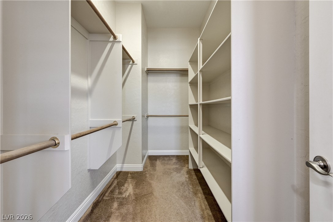 2793 Rosenhearty Drive Henderson, NV 89044 - Photo 42 of 85 This organized walk-in closet offers extensive shelving and multiple hanging rods for ample storage.