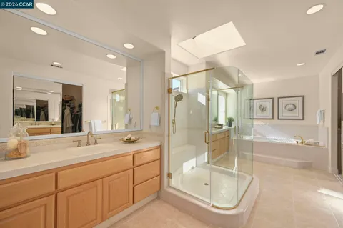 a bathroom with a granite countertop sink mirror bathtub and shower