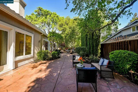 a view of a house with backyard and sitting area