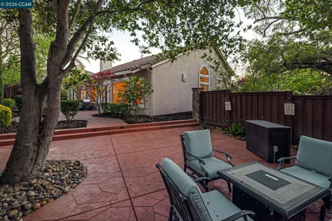 a backyard of a house with fountain table and chairs