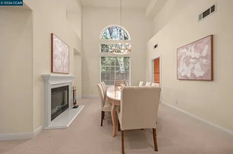 a dining room with furniture a fireplace and a chandelier