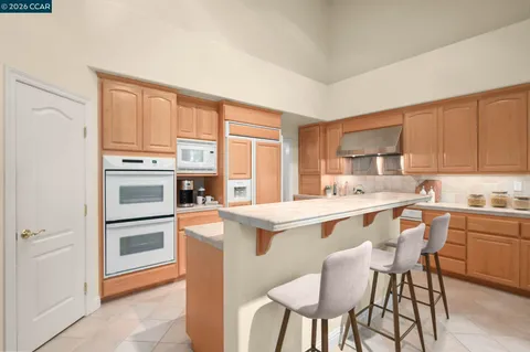 a kitchen with stainless steel appliances granite countertop a stove a sink dishwasher and a refrigerator