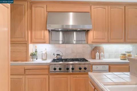a kitchen with granite countertop a stove and cabinets