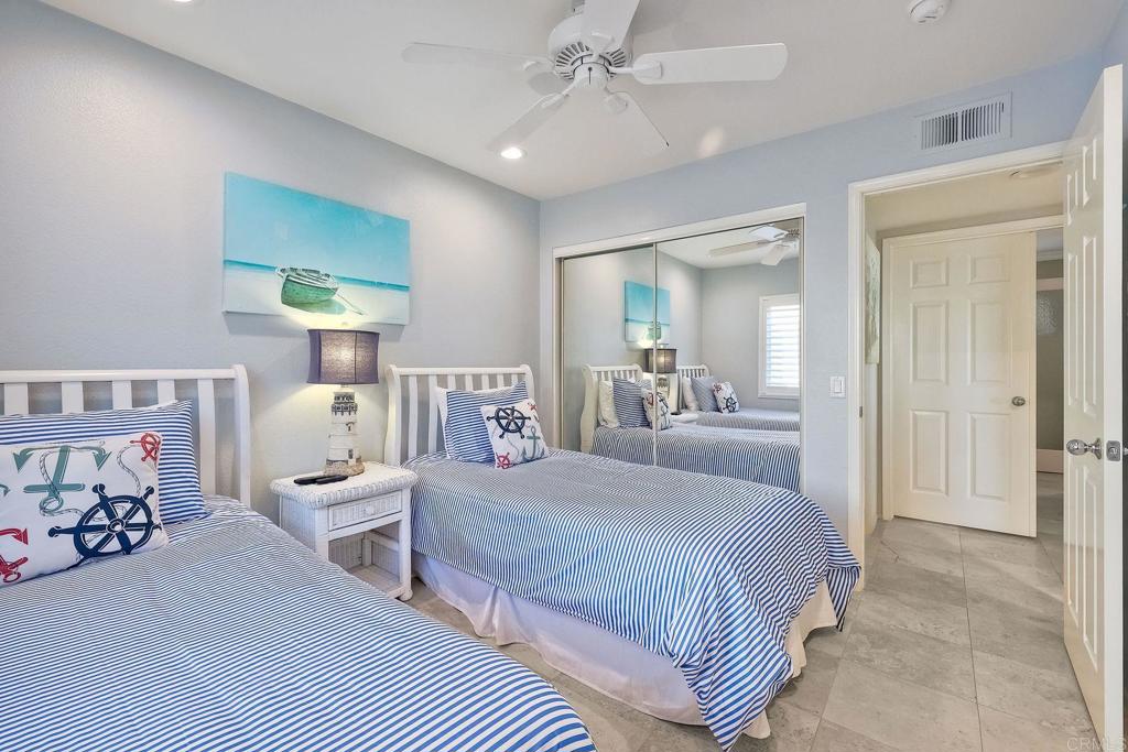 400 The Strand North, Unit 18 Oceanside, CA 92054 - Photo 11 of 19 a bedroom with a bed and a chandelier