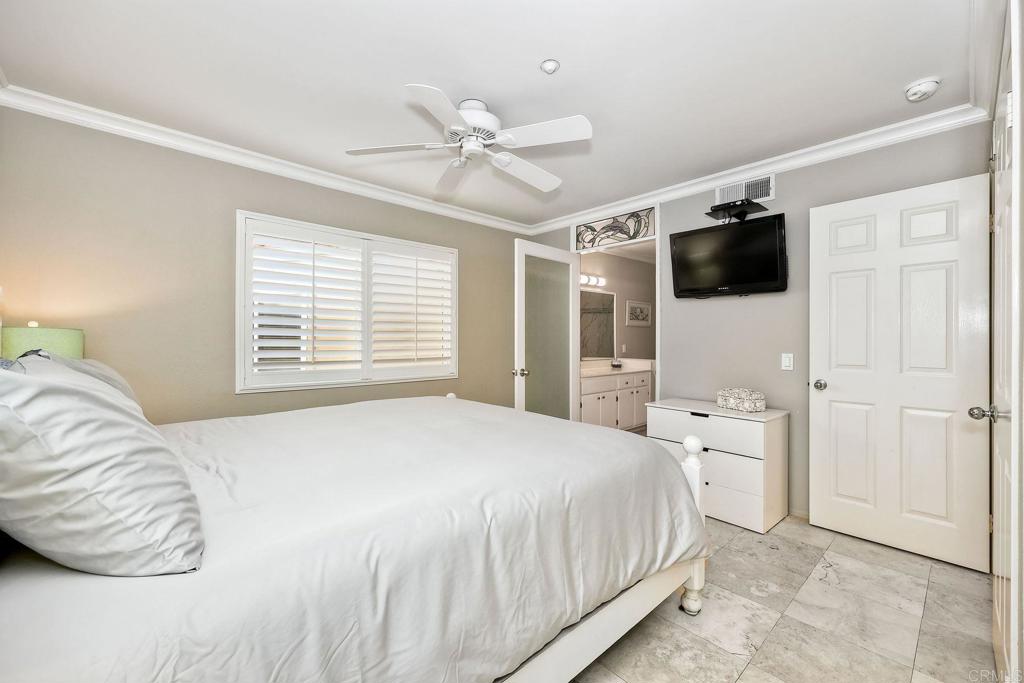 400 The Strand North, Unit 18 Oceanside, CA 92054 - Photo 8 of 19 a bedroom with a bed and a flat screen tv