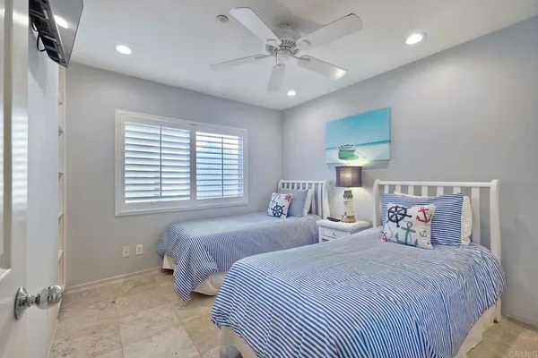a bedroom with two beds and a chandelier