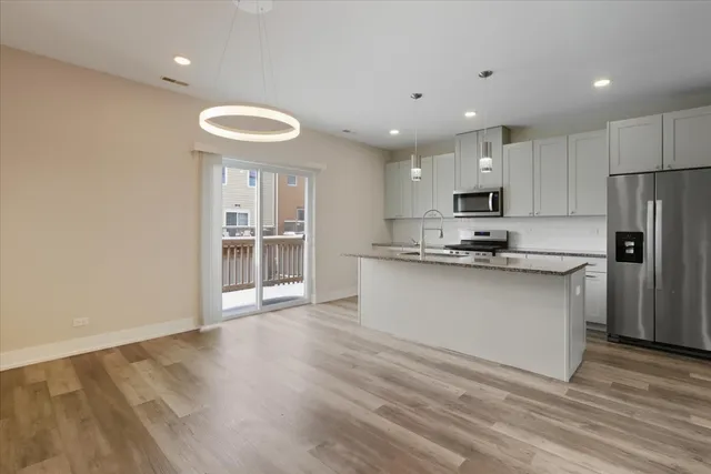 a kitchen with stainless steel appliances granite countertop a stove a sink and a refrigerator