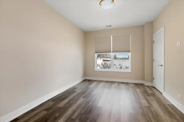 a view of room with window and wooden floor