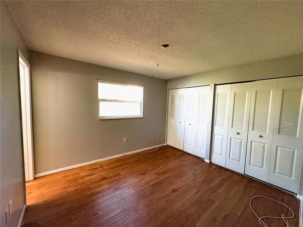 11333 Walsingham Road Largo, FL 33778 - Photo 15 of 34 a view of an empty room with wooden floor and a window