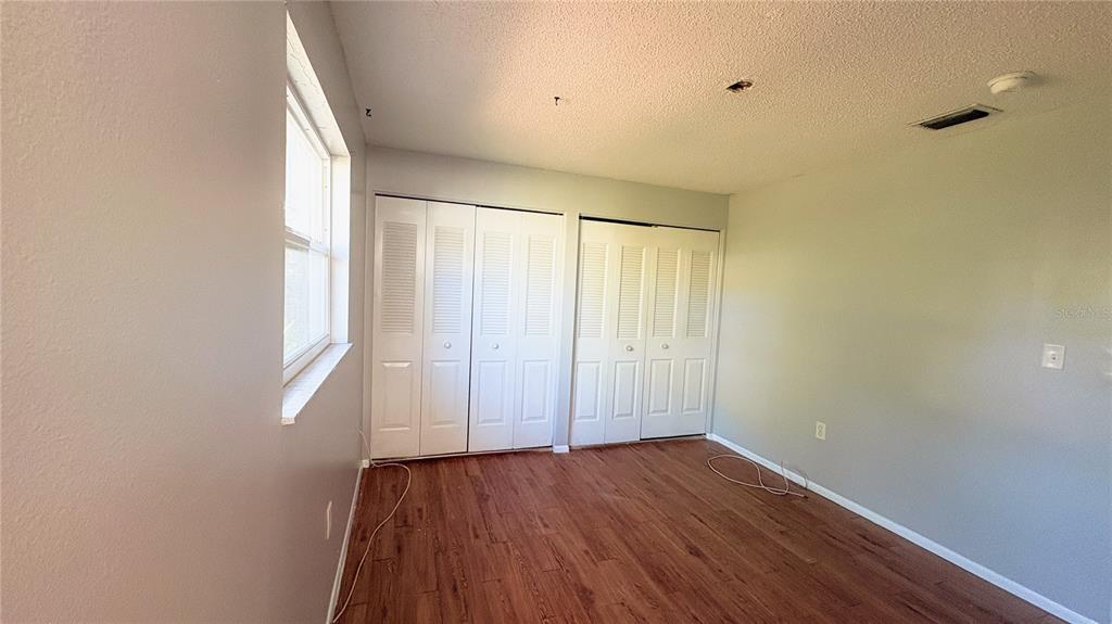 11333 Walsingham Road Largo, FL 33778 - Photo 21 of 34 a view of an empty room with wooden floor and a window