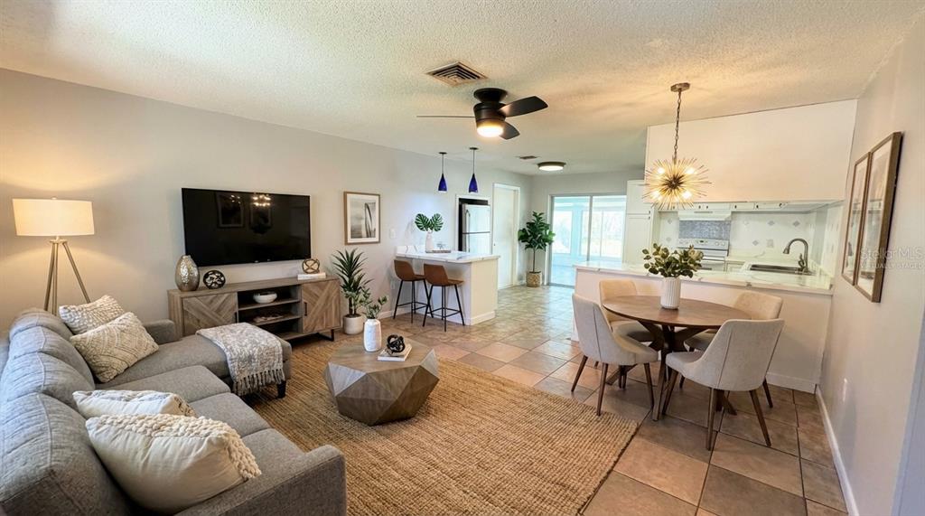 11333 Walsingham Road Largo, FL 33778 - Photo 4 of 34 a living room with furniture a flat screen tv and kitchen view