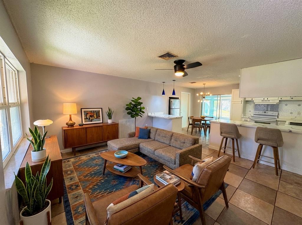 11333 Walsingham Road Largo, FL 33778 - Photo 5 of 34 a living room with furniture a ceiling fan and a rug