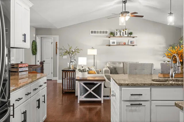 a spacious bedroom with a bed a couch and a chandelier