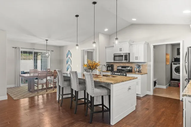 a view of a dining room with furniture a chandelier and wooden floor