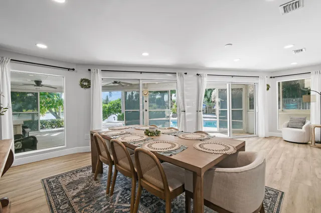 a dining room with stainless steel appliances granite countertop a table and chairs