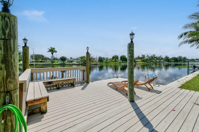 a view of a lake with wooden deck and a garden