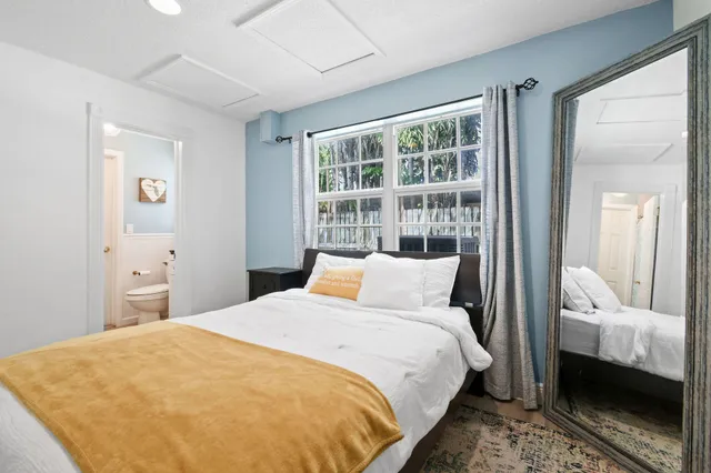 a bathroom with a toilet sink vanity and mirror