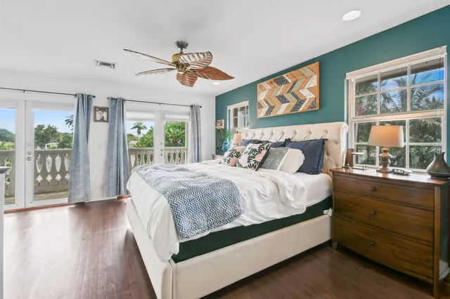 a bed sitting in a bedroom next to a window with a flat screen tv